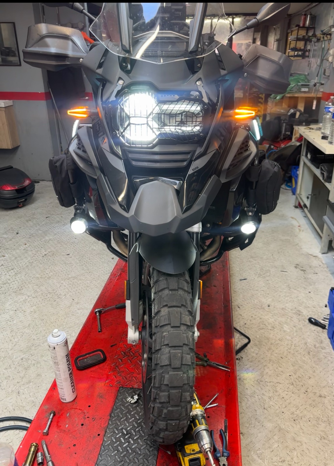 BMW GS Adventure avec feux LED additionnels allumés sur pont élévateur